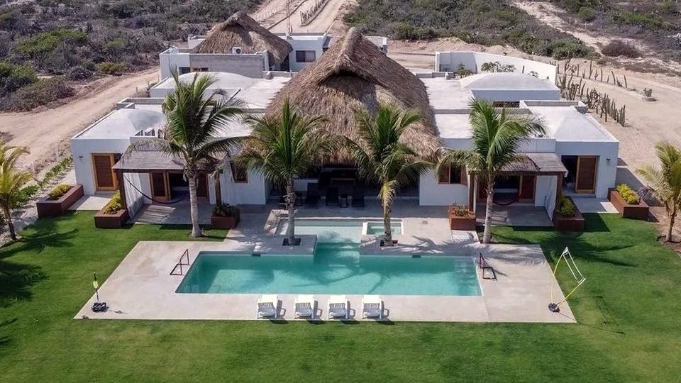 Aerial view of Villa 3, its palapa roofs, lawn and pool